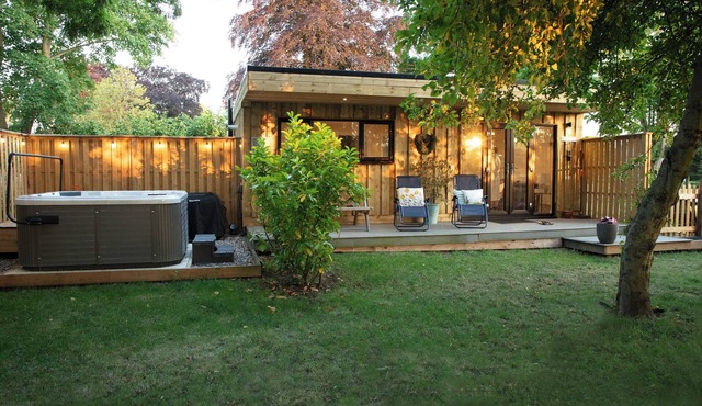 Countryside lodge with hot tub, sauna sessions, fire pit & space to gather for families & friends.